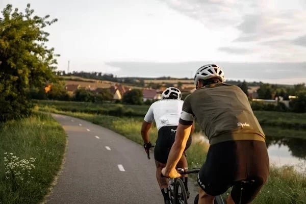 A bicycle tire shows signs of low pressure by squishing against the asphalt road.