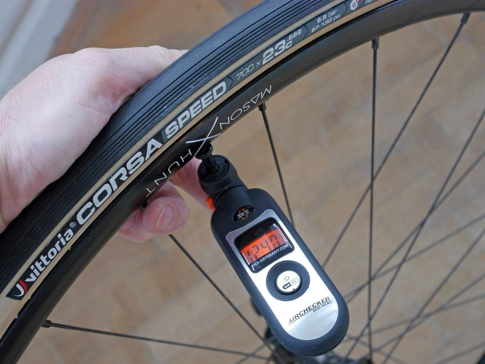 A cyclist prepares to check bike tire pressure in a bright, modern home garage.