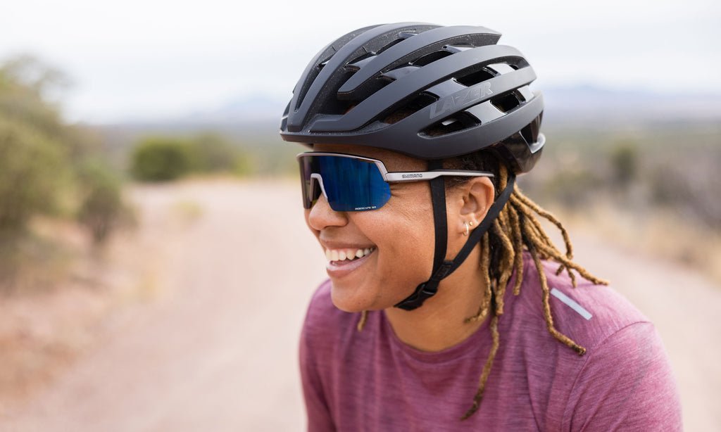 A modern bicycle helmet displayed on a wooden table in a bright shop.
