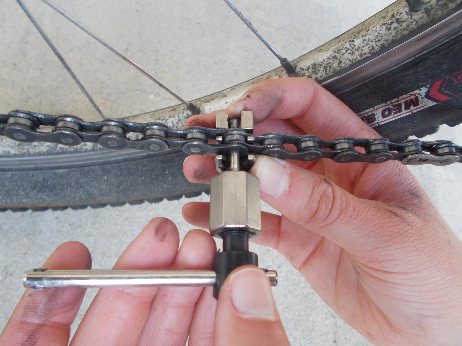 A muddy dirt bike wheel showing the impact of trail conditions on spoke tension.