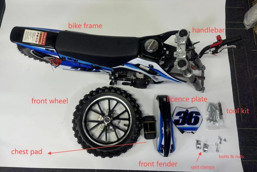 A mechanic checks the front wheel rotation of a dirt bike to confirm assembly.