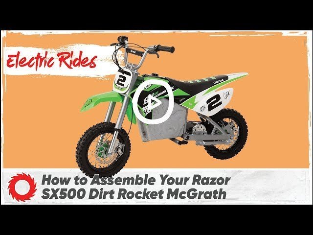 A professional motocross dirt bike being carefully assembled in a clean workshop garage.