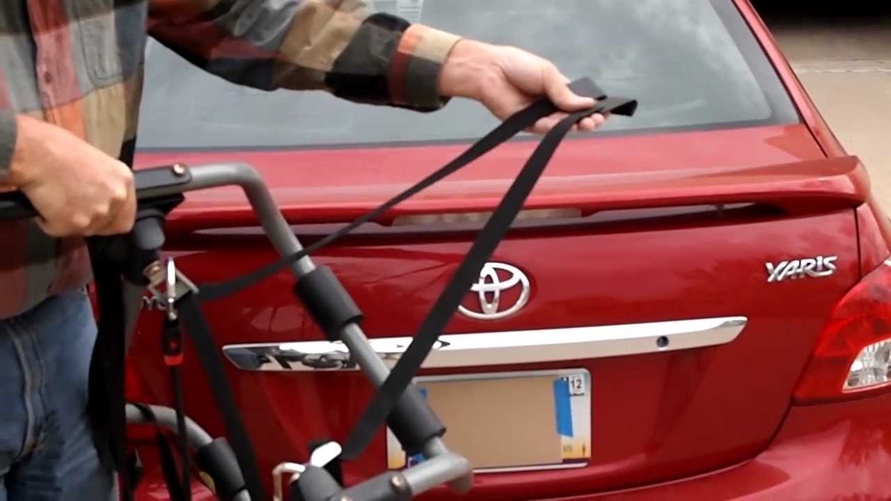 A Rhode Gear bike rack attached to the trunk of a silver car.