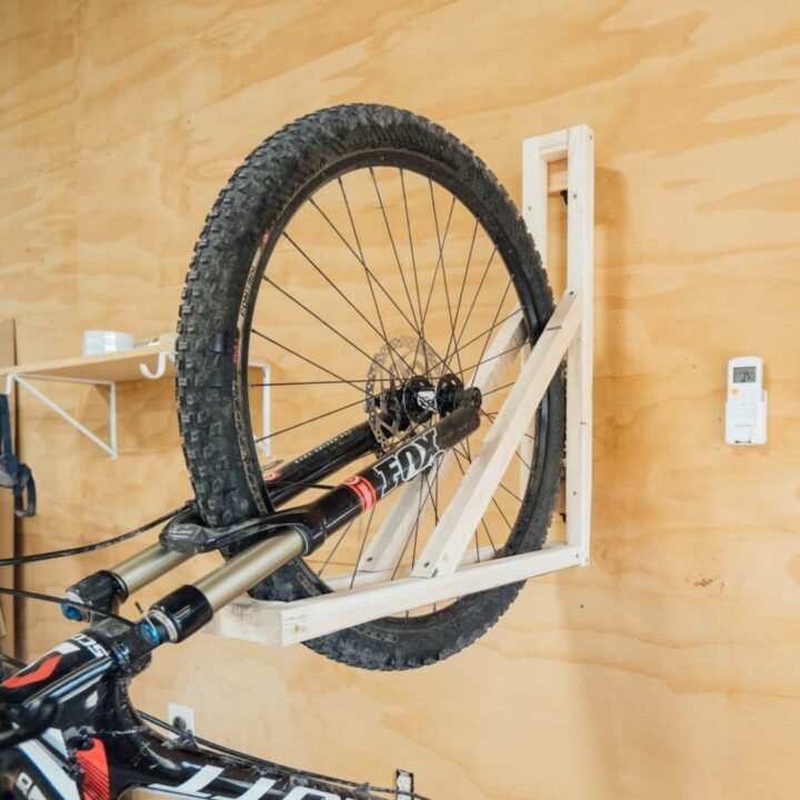 A person checking a tablet while inspecting a finished hanging bike rack.