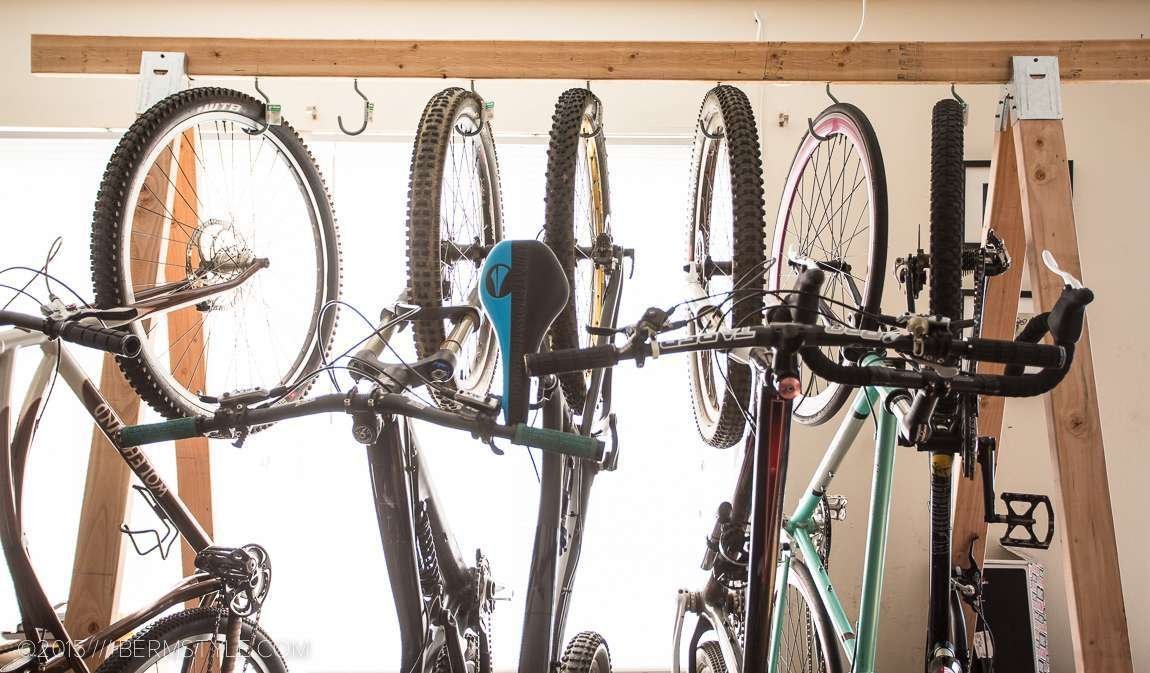 A neatly organized hanging bike rack mounted on a clean garage wall.