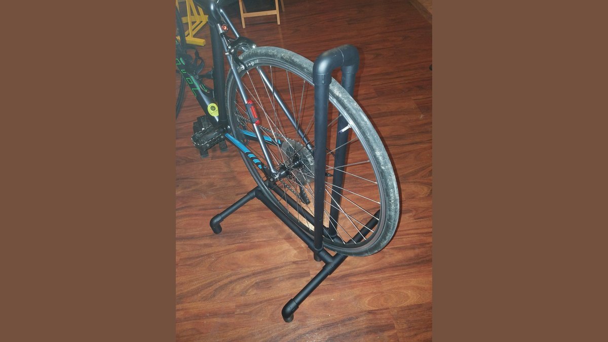 A completed white PVC bike rack holding a bicycle in a clean garage.