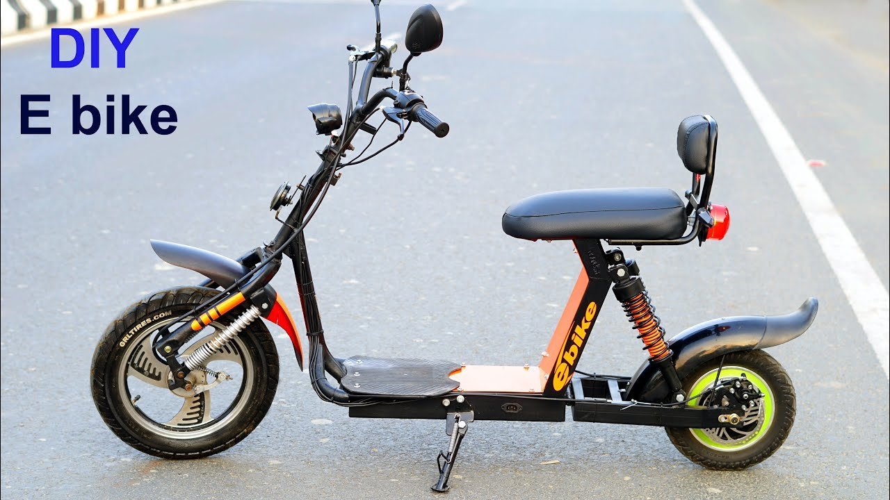 A completed electric scooter standing against a white wall in a bright studio.