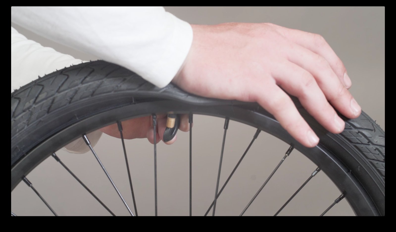A person checking their BMX bike tire after a successful repair in a park.