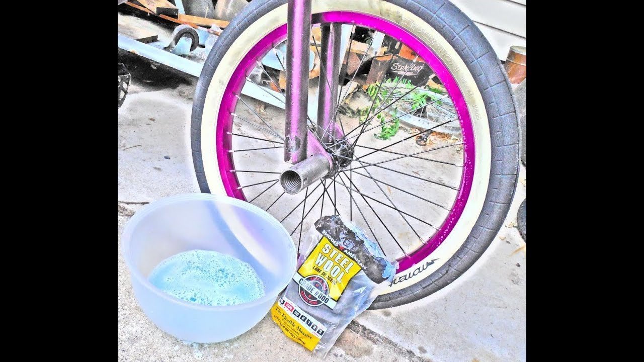A hand touching the smooth and clean surface of a white bike tire.