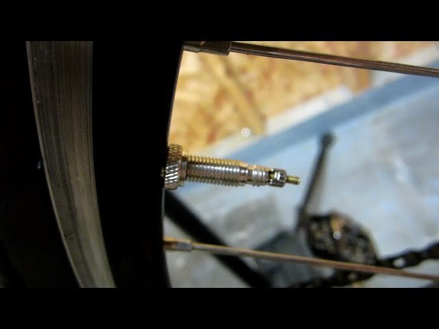 A leaking bicycle valve being tested with a drop of soapy water.