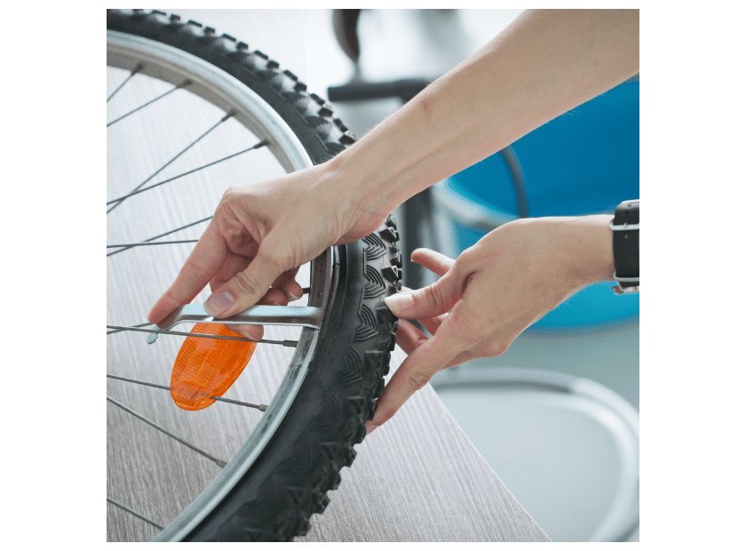 Essential bicycle repair tools laid out on a clean wooden workbench.