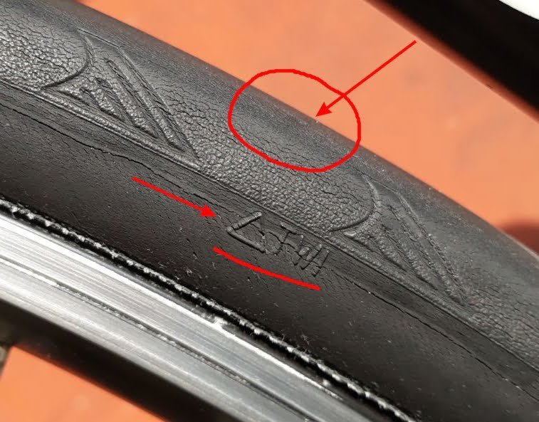 A bicycle tire showing cracks caused by prolonged exposure to direct sunlight.