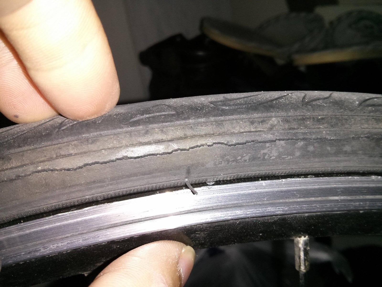 A close-up view of a cracked bike tire sidewall showing signs of age.