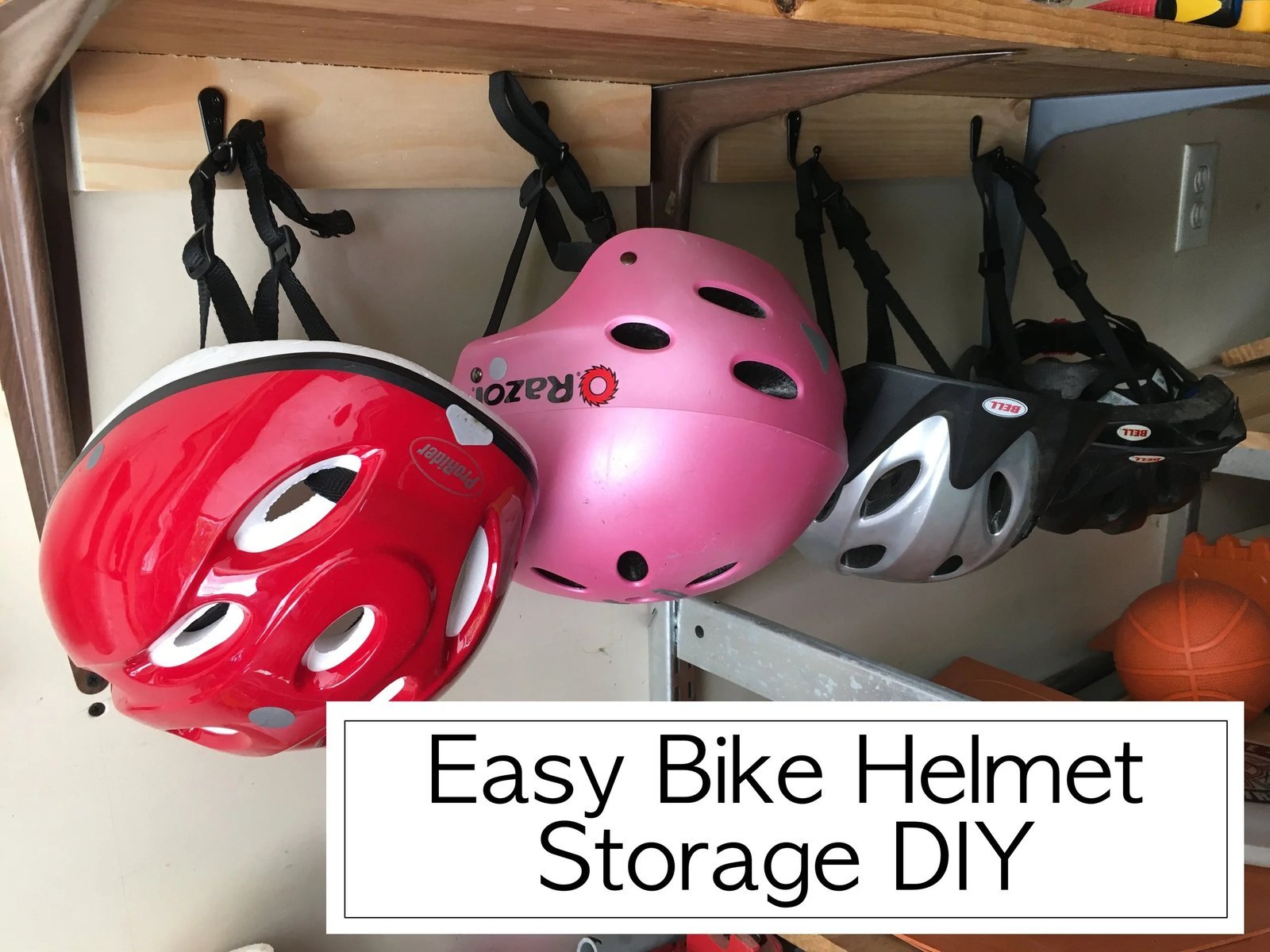 Essential tools and hardware for hanging bike helmets on a wooden surface.