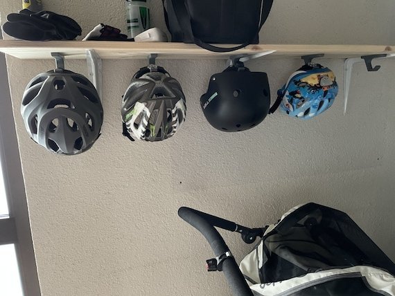 A properly installed bike helmet hanging securely on a wall hook.