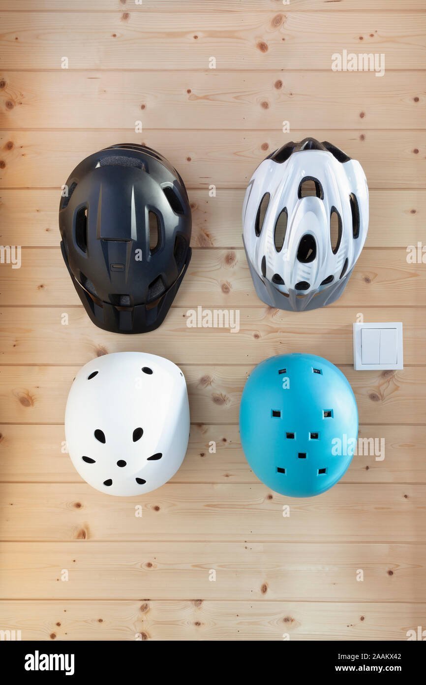 Hands adjusting a bike helmet on a secure wall storage hook.