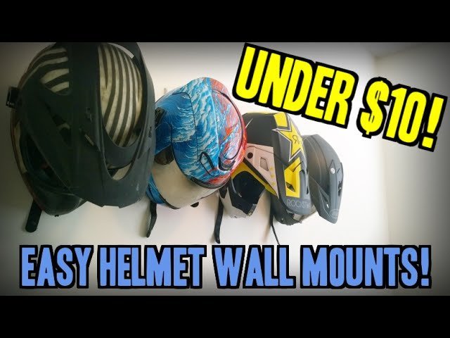 Three bike helmets hanging neatly on a modern white wall in a home.