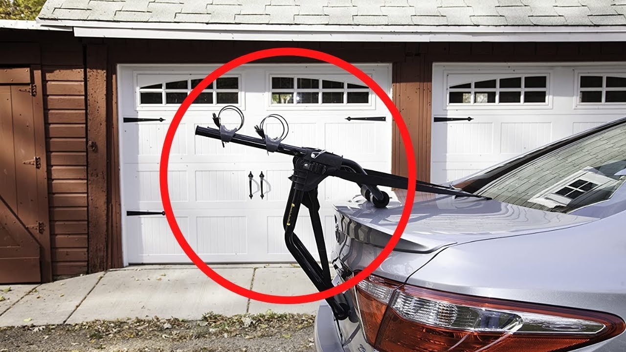 Mechanic installing a sturdy black Schwinn bike rack onto a bicycle frame.