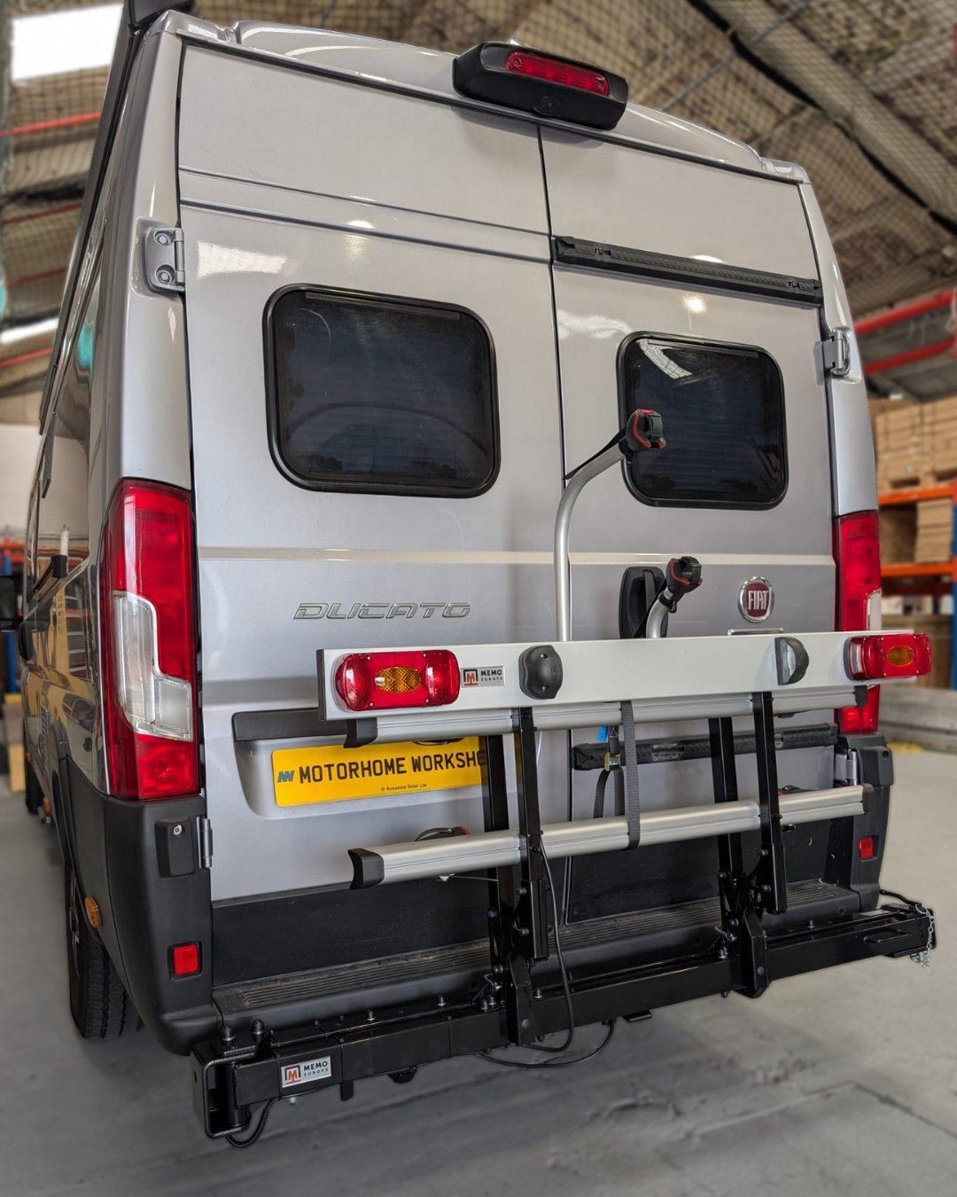 A laptop showing installation instructions for a bike rack inside a modern van.