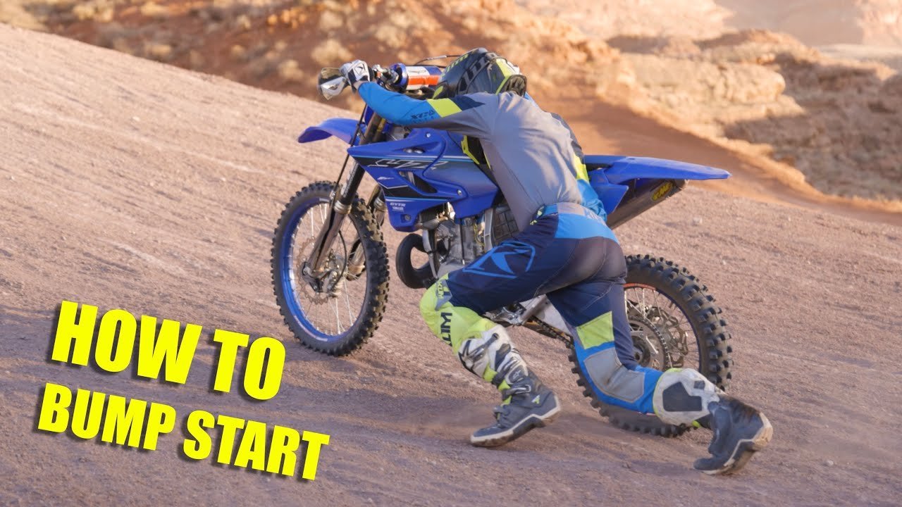 A rugged dirt bike parked on a forest trail during a golden sunset.