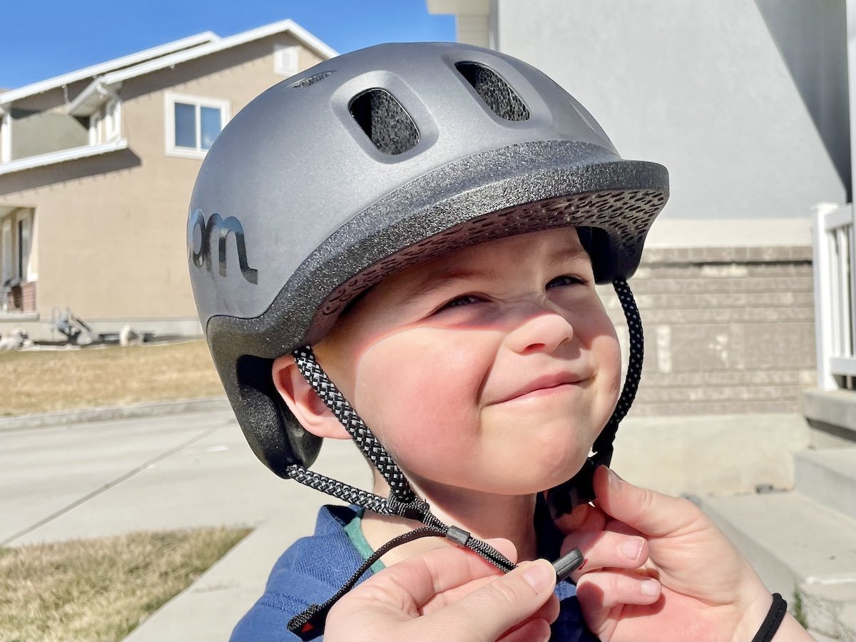 A bicycle helmet sits on a table with a measuring tape nearby.