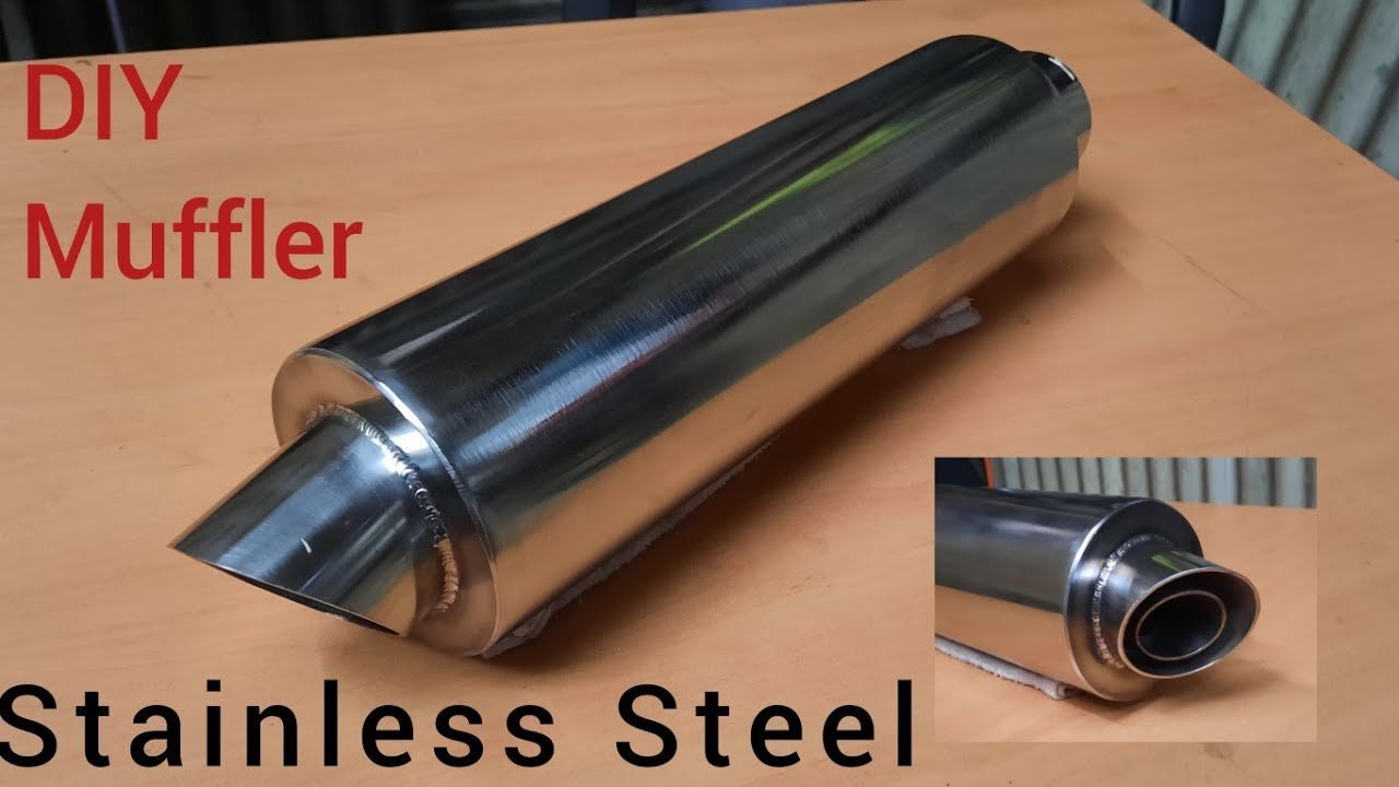 A custom dirt bike silencer installed on a motorcycle in a garage.