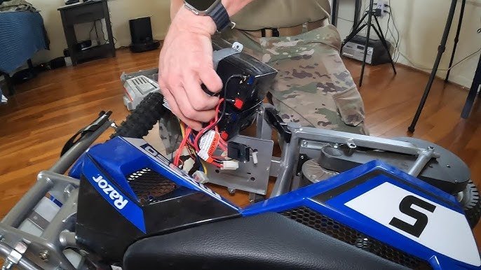 A mechanic reviewing maintenance steps for a Razor dirt bike repair.