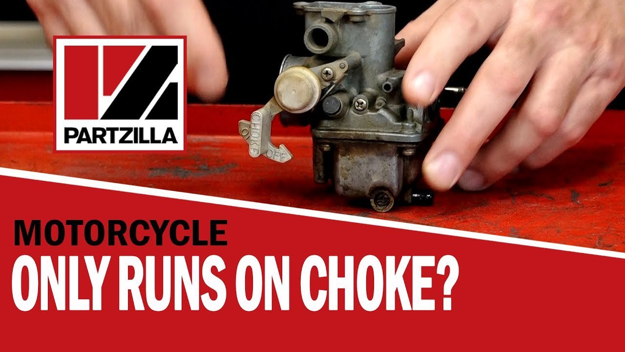 A close-up view of a dirt bike engine focusing on the choke mechanism.