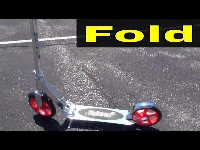 Hands adjusting the quick-release lever on a metal scooter steering column.