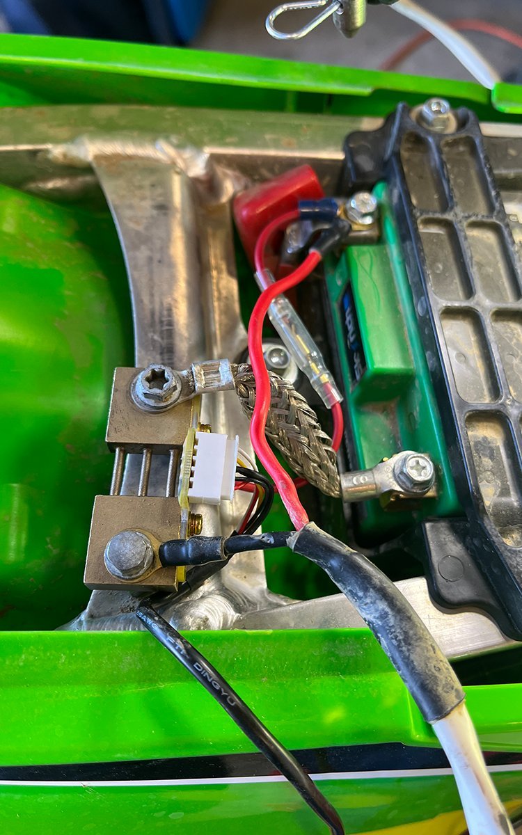 Close up of a mechanic securing wiring connections for a dirt bike headlight.
